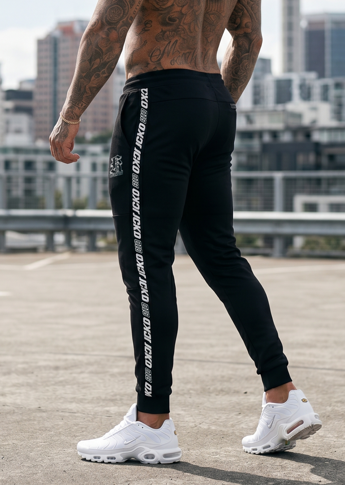 Athleisure outfit in an urban setting: black Core-Lock tapered joggers with side branding worn with white sneakers