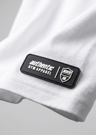 RTLS raised rubber badge, close-up of the hem patch detail on a white garment